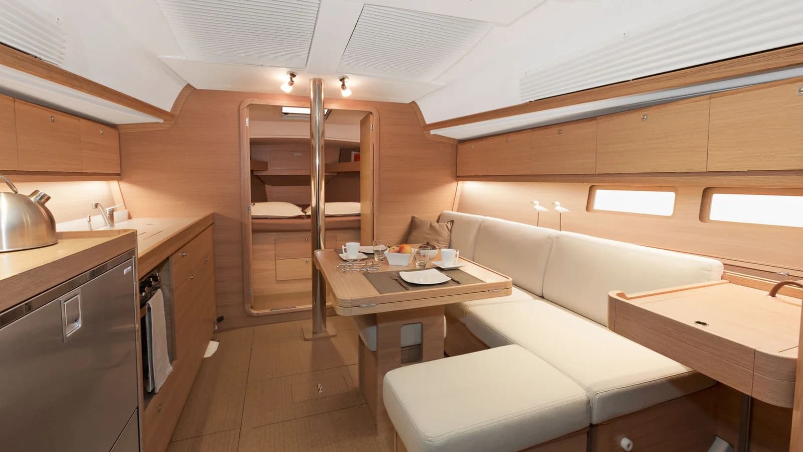 Le carré du Dufour 382 : table, banquette et cuisine en bois clair