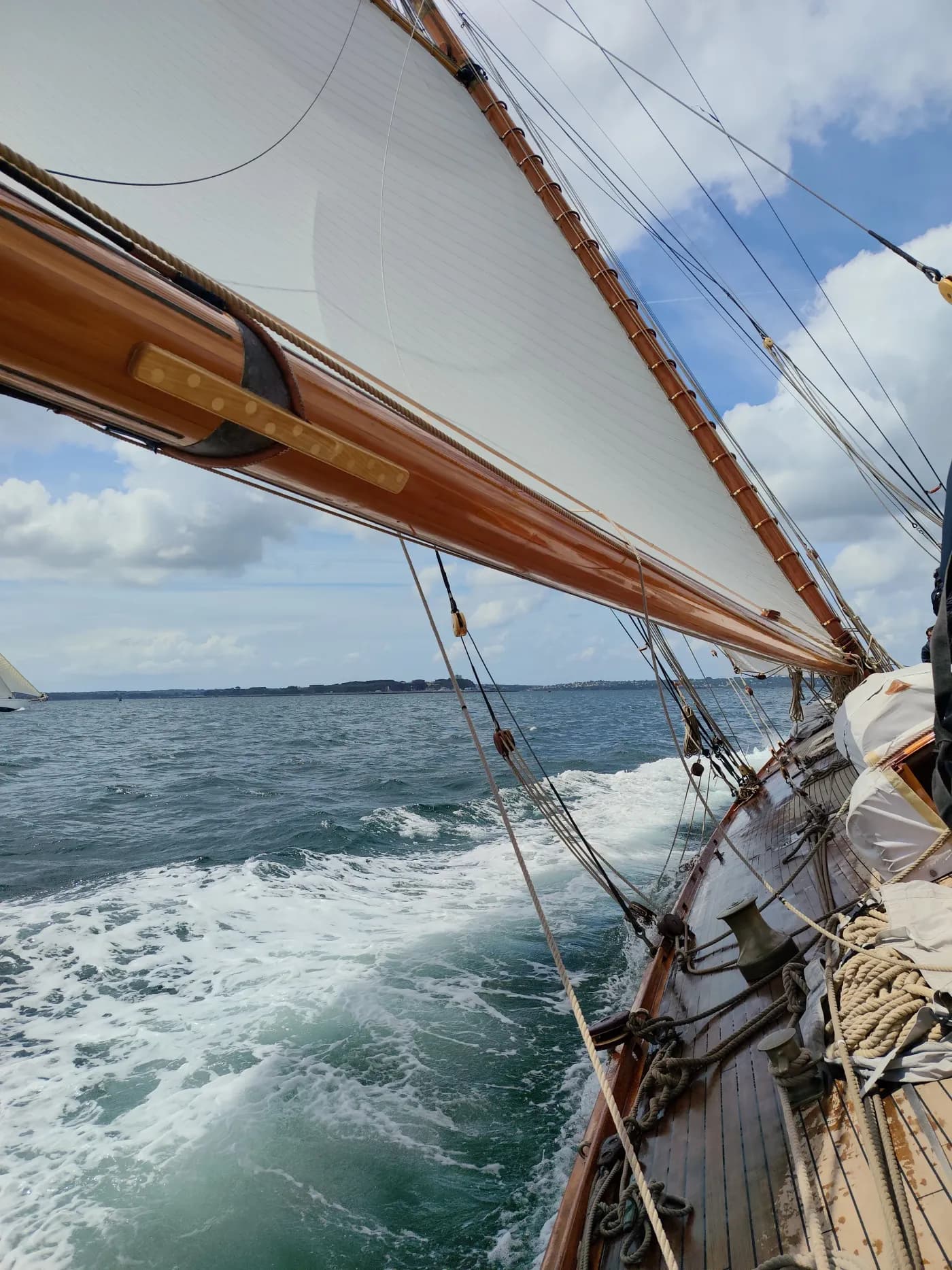 Vue du pont sous voiles, cap vers la côte, sillage dans la mer